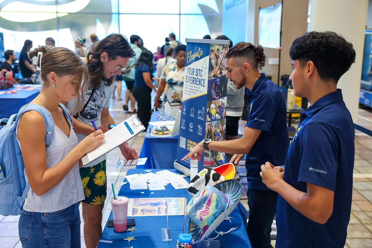 Students visit a Club Rush booth at OTC, signing up for campus organizations.