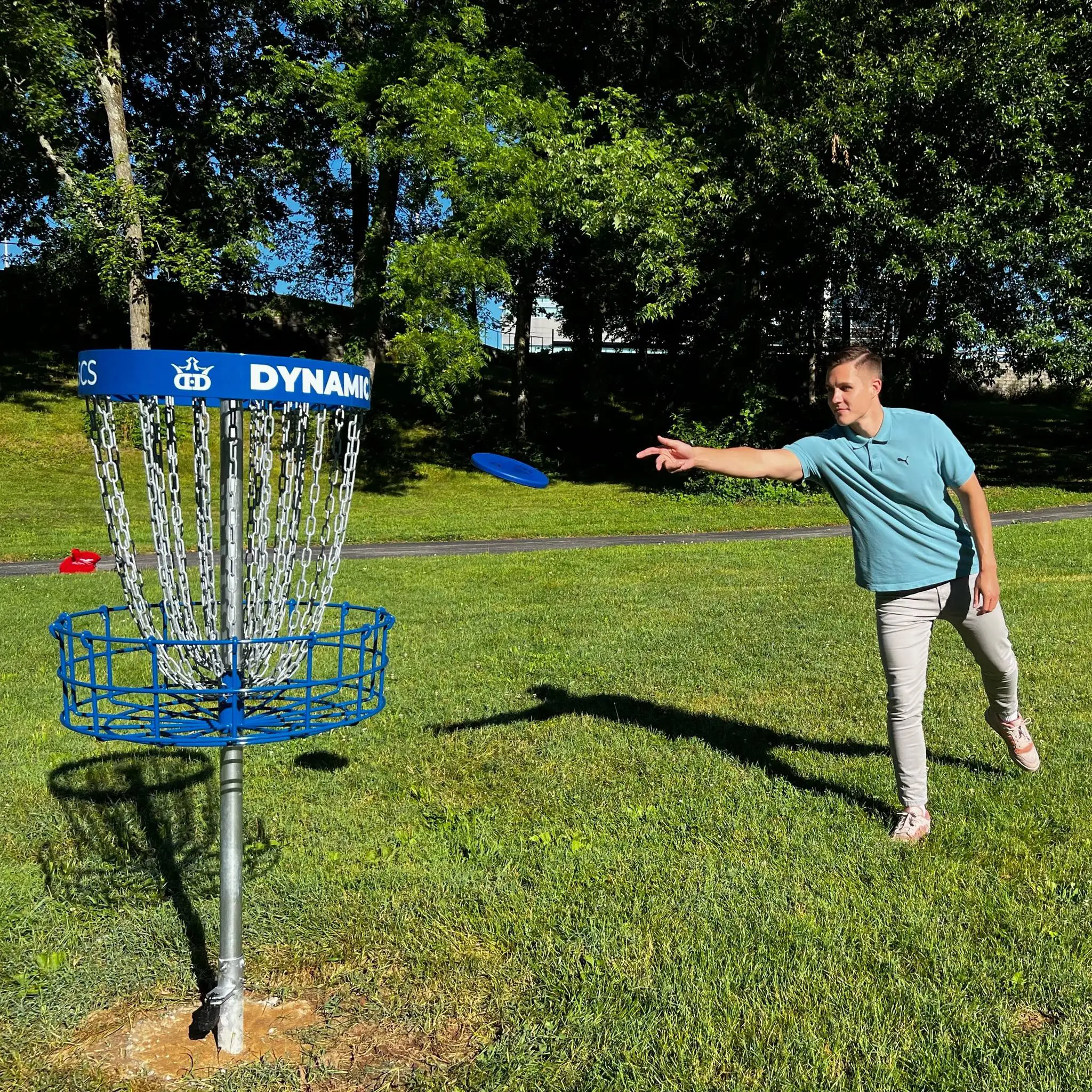 Student throws a disc toward the basket on OTC’s outdoor disc golf course.