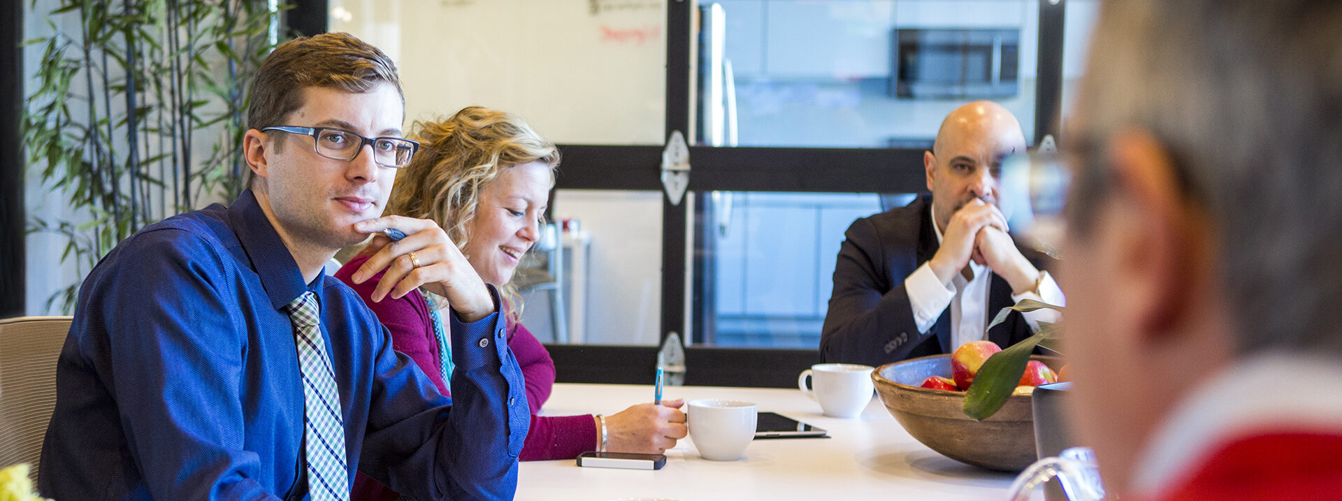Employees at a conference table discuss a marketing stategy.