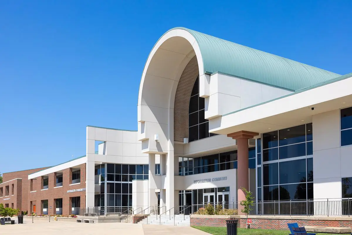 Exterior view of the Information Commons building at OTC Springfield under a bright blue sky.