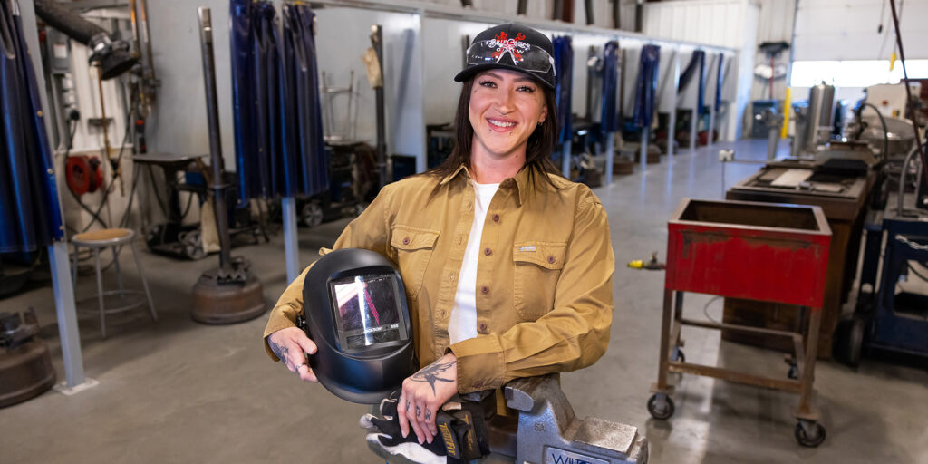 Ozarks Tech Welding student Bryanna Shaffner is depicted holding a welding mask and gloves