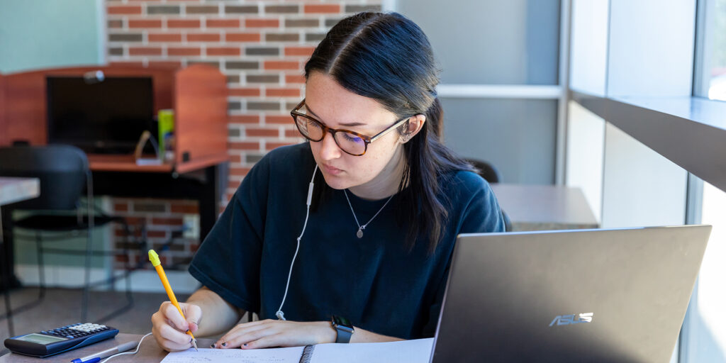 A Dual Credit student is depicted studying 