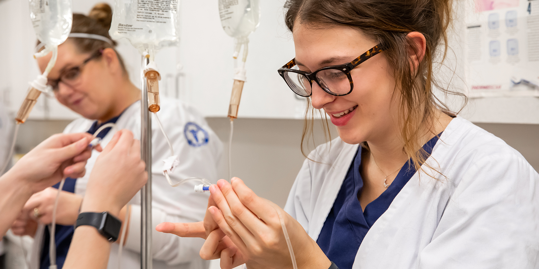 Ozarks Tech Practical Nursing Program students are depicted learning hands-on about IV therapy in the lab
