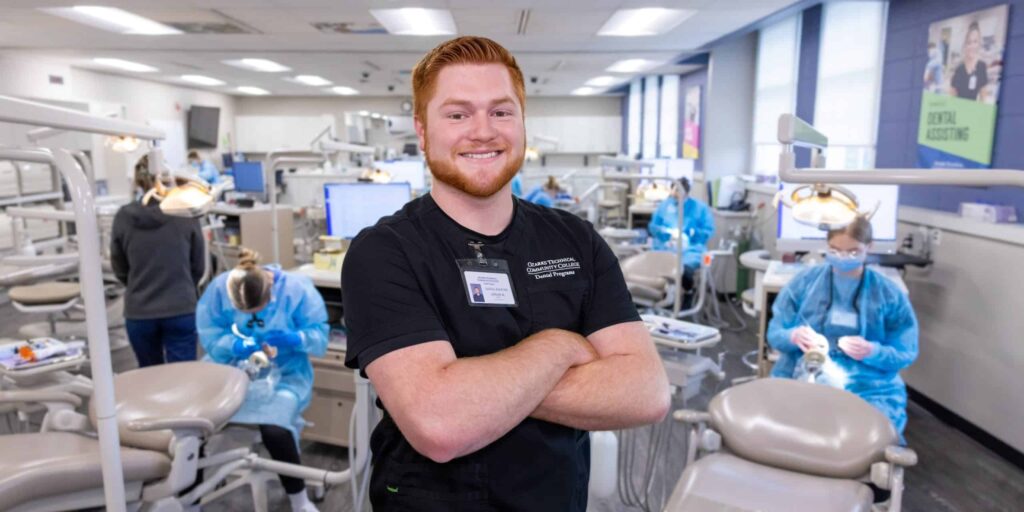 Featured student stands in dental clinic.