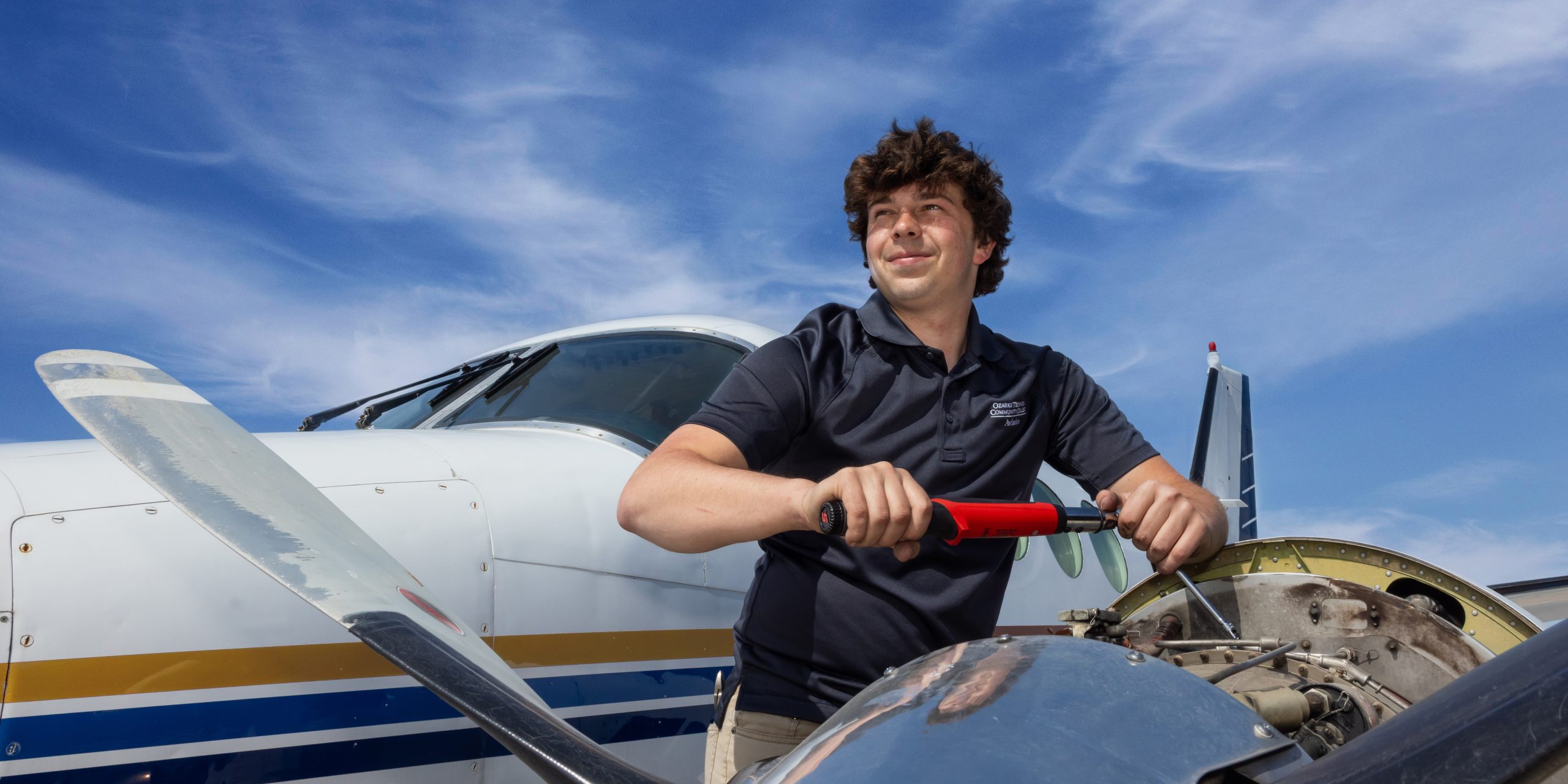 A person is depicted repairing a small airplane