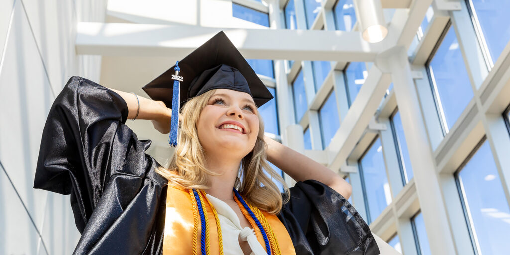 Student smiling in graduation regalia.