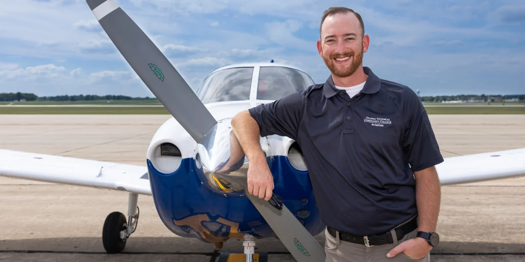 Man stands in front of small airplane