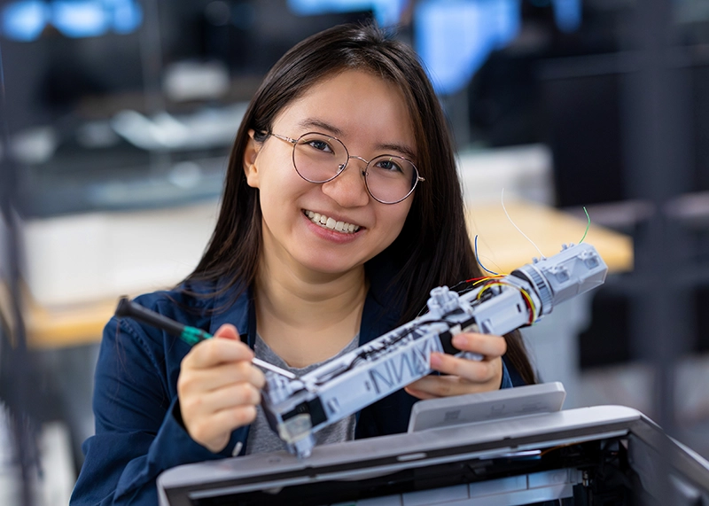 Students holds project in front of 3D printer