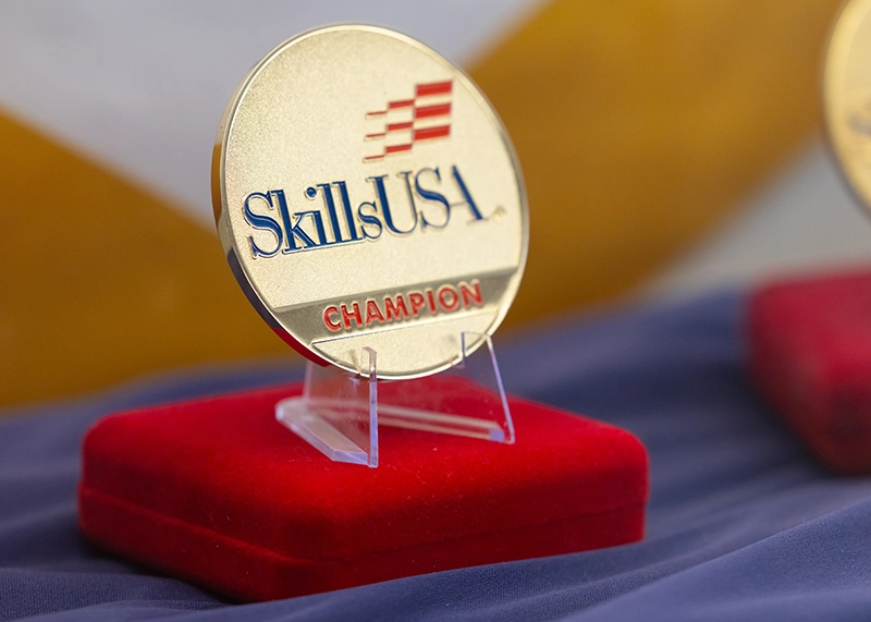 SkillsUSA competition medal displayed on a stand.