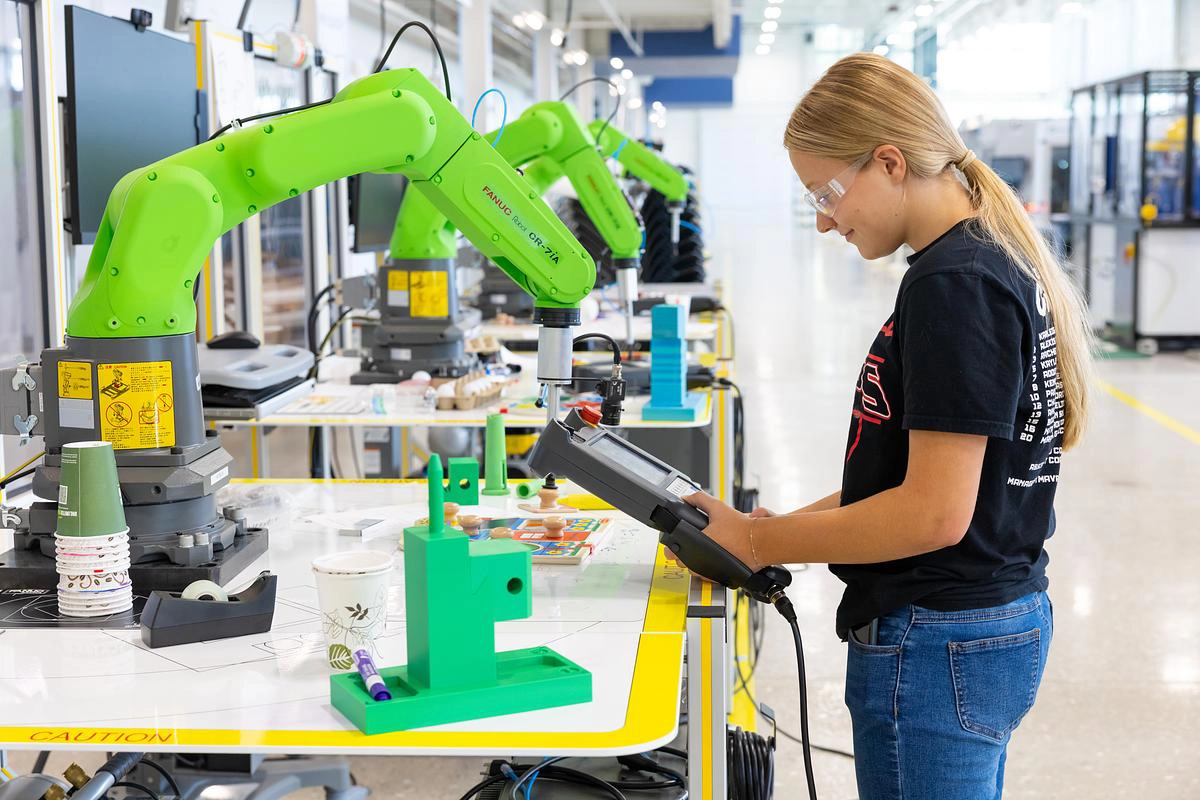 Student operates a robotic arm at automation and robotics camp.