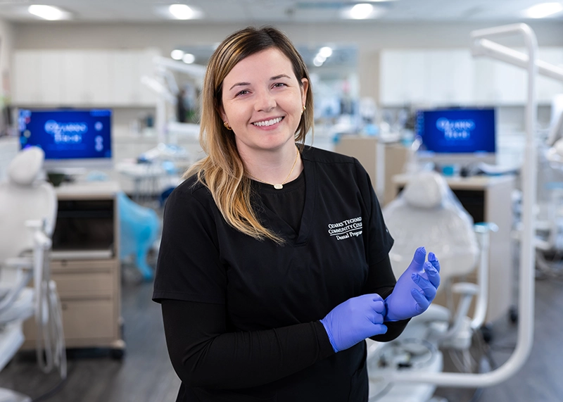 Alex Smith, a dental hygiene student, smiles in a dental lab
