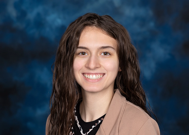 Portrait of a smiling woman wearing a tan jacket