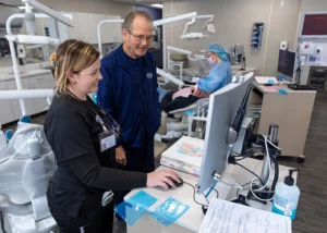 Dental hygiene student and instructor standing in front of a computer in the dental clinic at Ozarks Tech.
