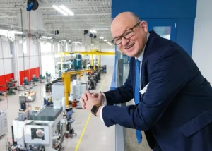 Ozarks Tech Chancellor Dr. Hal Higdon stands on a balcony overlooking the high bay area of the Plaster Manufacturing Center on the Springfield campus.