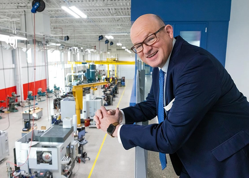 Ozarks Tech Chancellor Dr. Hal Higdon stands on a balcony overlooking the high bay area of the Plaster Manufacturing Center on the Springfield campus.