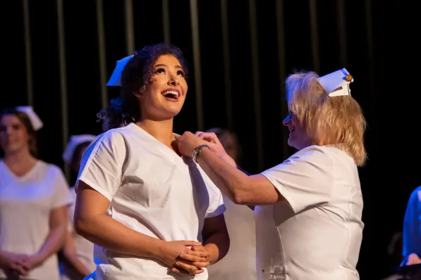 New nurse smiles broadly at pinning ceremony